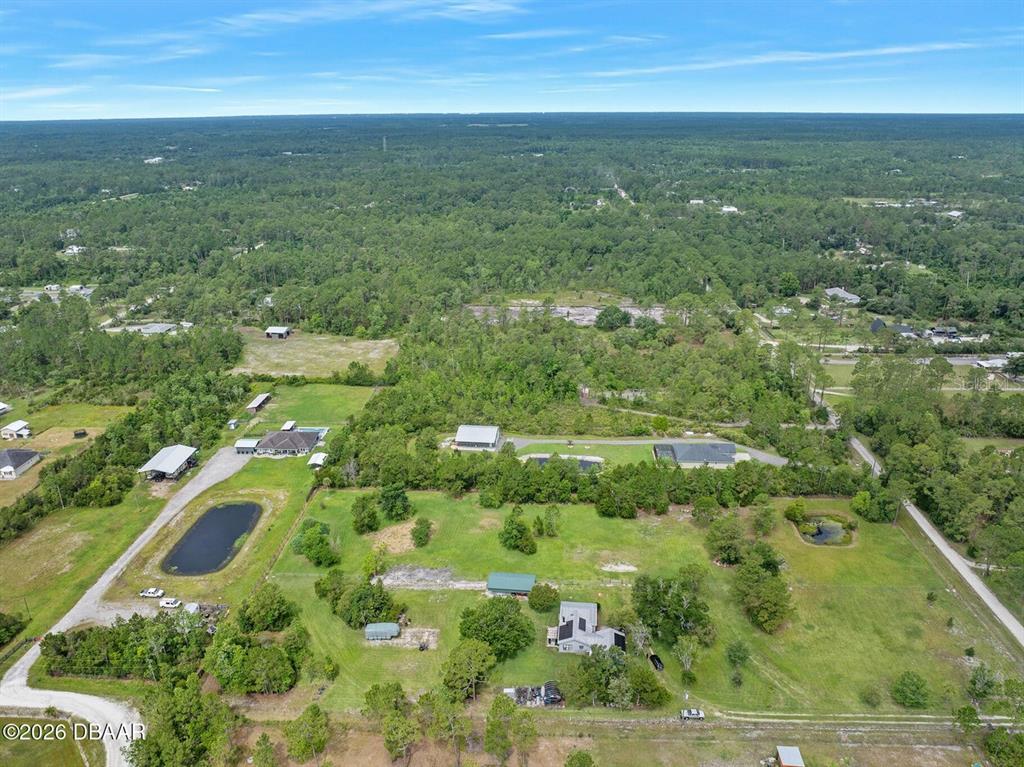 An aerial view shows multiple rural properties with houses, outbuildings, and ponds on grassy lots — 4034 BUDD ROAD, NEW SMYRNA BEACH, FL