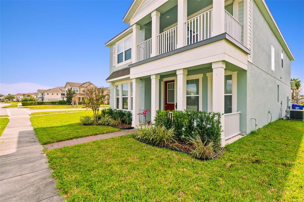 A two-story house with a front porch, balcony, and green stucco exterior — 2800 CELLO LANE, KISSIMMEE, FL