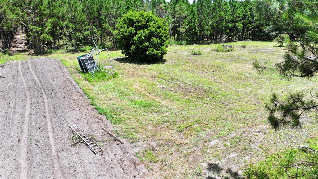 An aerial view shows a grassy lot with a fallen basketball hoop and a ladder — 9970 SE 154TH AVENUE, WHITE SPRINGS, FL