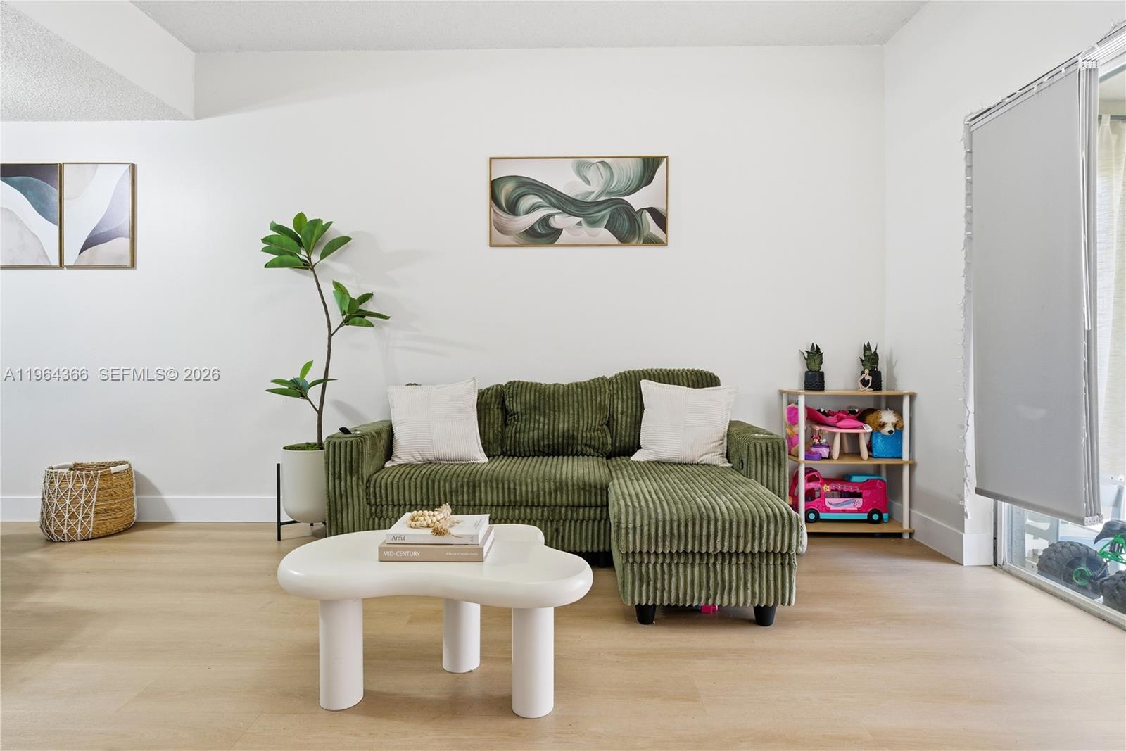A living room features a green corduroy sectional sofa, a white coffee table, and a plant — 2 Simonton Cir, Weston FL 33326, WESTON, FL