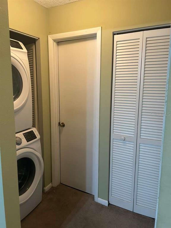 A laundry area features a stacked washer and dryer next to a closet with louvered doors — 39132 COUNTY ROAD 54 UNIT 2084, ZEPHYRHILLS, FL