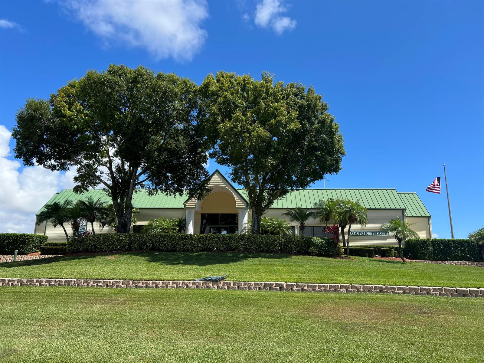 A low-slung building with a green metal roof sits behind a manicured lawn and trees — 4310 Gator Trace Circle, Fort Pierce FL 34982, FORT PIERCE, FL