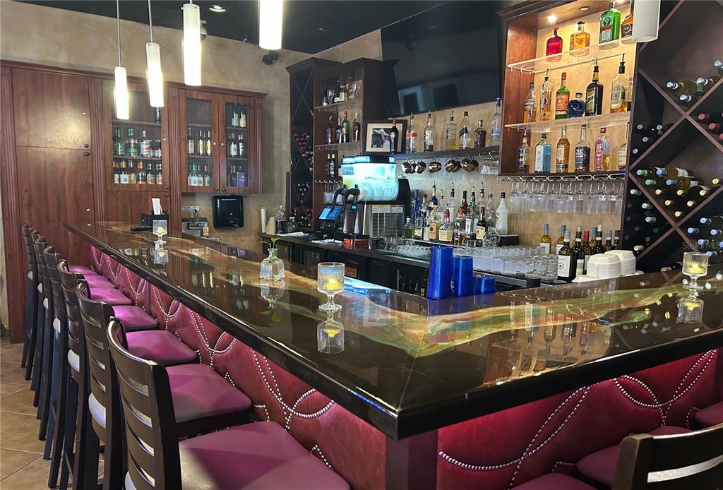 A bar area features a polished countertop with a colorful inlay and purple tufted stools — 515 27TH STREET E UNIT 9, 10, 11, BRADENTON, FL