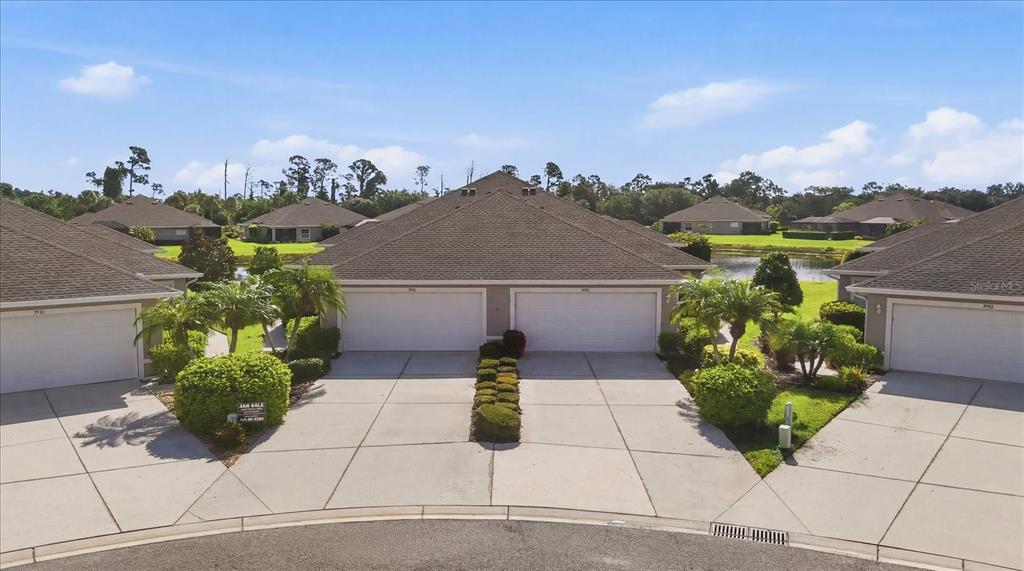 An aerial view of a residential duplex with attached garages and a shared driveway — 5968 IBIS COURT, NORTH PORT, FL