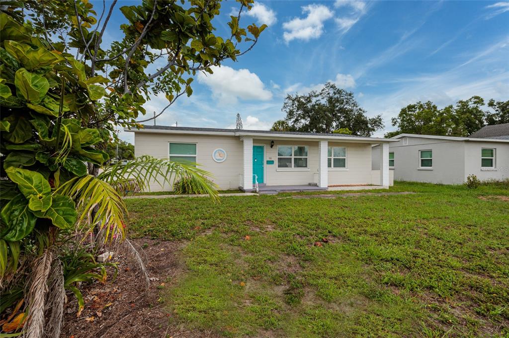 A single-story house with a light-colored exterior, a turquoise front door, and a covered porch — 101 40TH AVENUE NE, ST PETERSBURG, FL