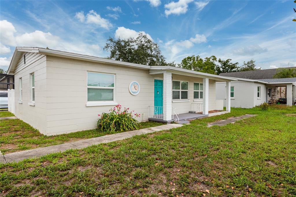 A single-story, light-colored house with a teal front door and a covered porch — 101 40TH AVENUE NE, ST PETERSBURG, FL