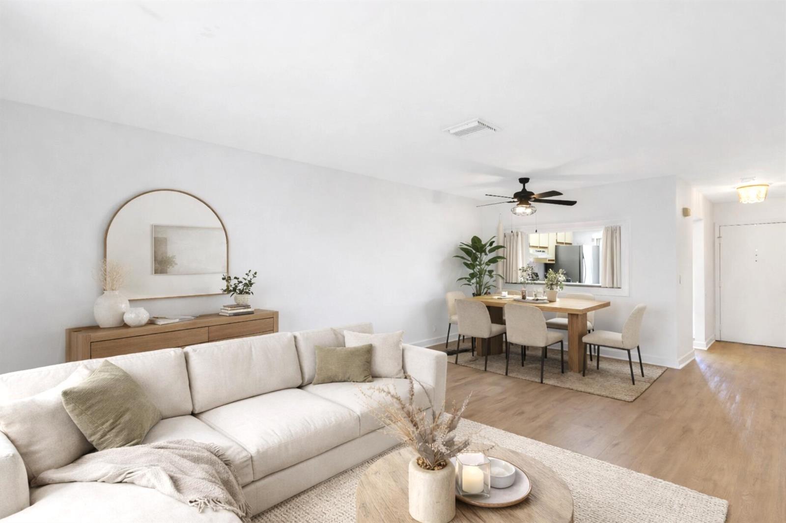 A bright living and dining area features a beige sectional sofa, wooden furniture, and flooring — 3275 Frederick Boulevard # 17u, Delray Beach FL 33483, DELRAY BEACH, FL