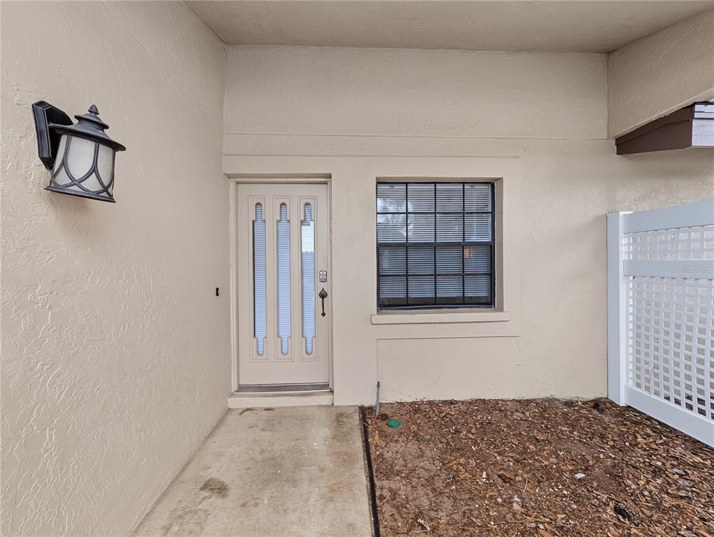 The exterior view shows a beige front door with three glass panels and a window — 4554 MORNINGSIDE UNIT 42, SARASOTA, FL