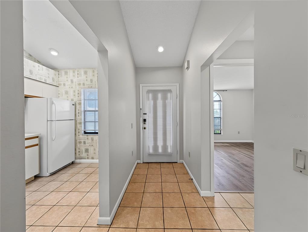 A tiled entryway leads to a kitchen on the left and a living area beyond — 4554 MORNINGSIDE UNIT 42, SARASOTA, FL