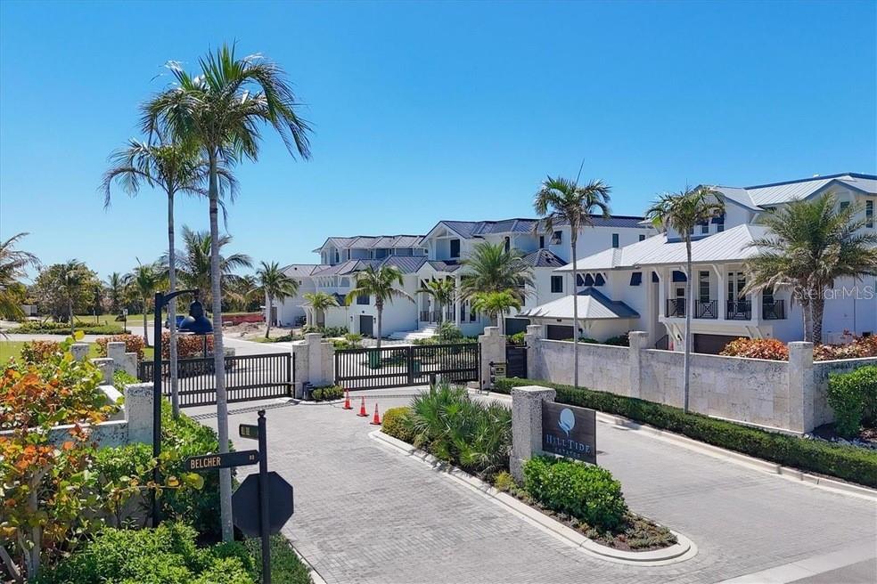 A gated entrance with a stone sign leads to white multi-story houses and palm trees — 870 GRANDE PASS WAY, BOCA GRANDE, FL