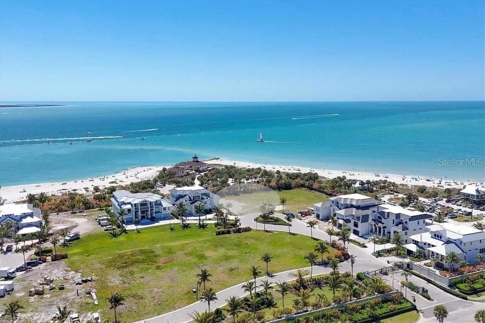 An aerial view shows luxury beachfront homes situated along a sandy coastline and blue ocean — 870 GRANDE PASS WAY, BOCA GRANDE, FL