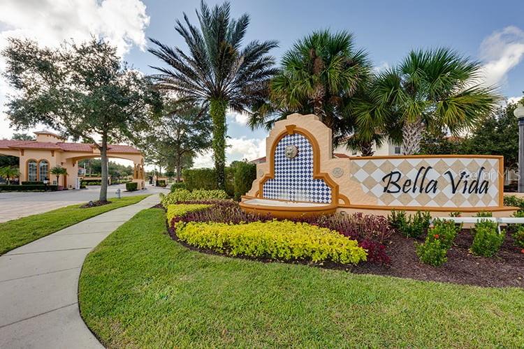 A decorative monument sign for Bella Vida stands near a sidewalk and palm trees — 294 MARCELLO BOULEVARD, KISSIMMEE, FL