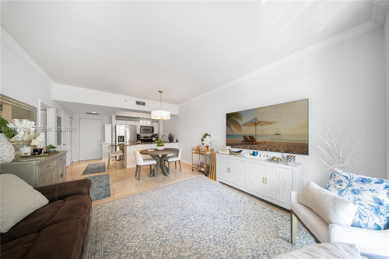 A living room and dining area feature tile flooring, white walls, and a large television — 7290 SW 90th St # 308, Miami FL 33156, MIAMI, FL