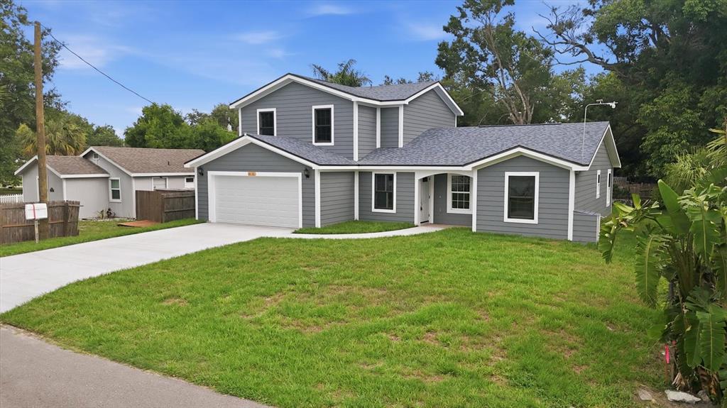 A gray two-story house with a white garage door and a green lawn — 1615 31ST AVENUE E, BRADENTON, FL