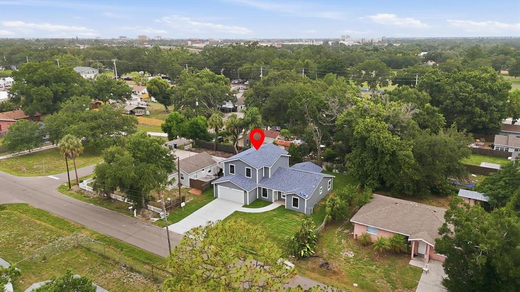 An aerial view shows a two-story gray house with a blue roof and a driveway — 1615 31ST AVENUE E, BRADENTON, FL