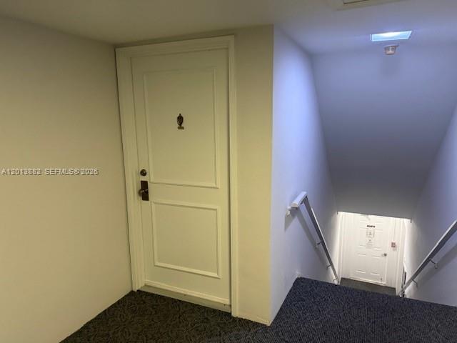 A white door stands at the top of a carpeted staircase leading to a lower level — 170 Cypress Club Dr # 733, Pompano Beach FL 33060, POMPANO BEACH, FL
