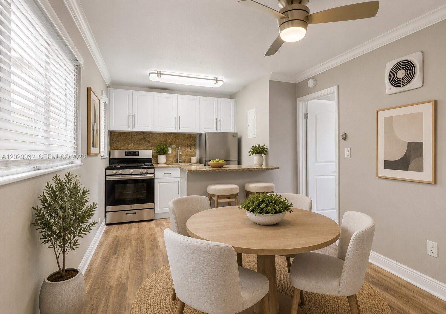 A kitchen and dining area feature white cabinets, stainless steel appliances, and a round table — 1014 Salzedo St # 211, Coral Gables FL 33134, CORAL GABLES, FL