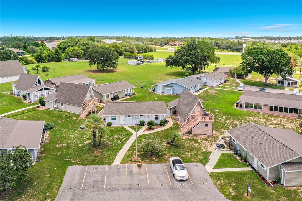 An aerial view shows several residential buildings with parking spaces in the foreground — 10301 US HIGHWAY 27 UNIT 22, CLERMONT, FL