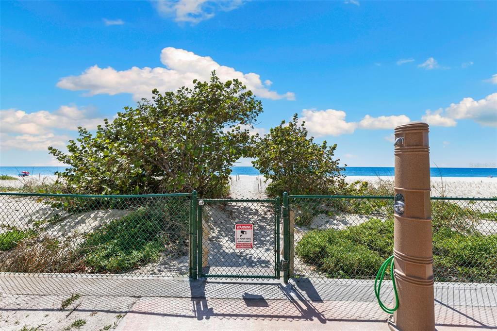 A gated beach access path leads through sand dunes to the ocean under a blue sky — 900 GULF BLVD UNIT 104, INDIAN ROCKS BEACH, FL