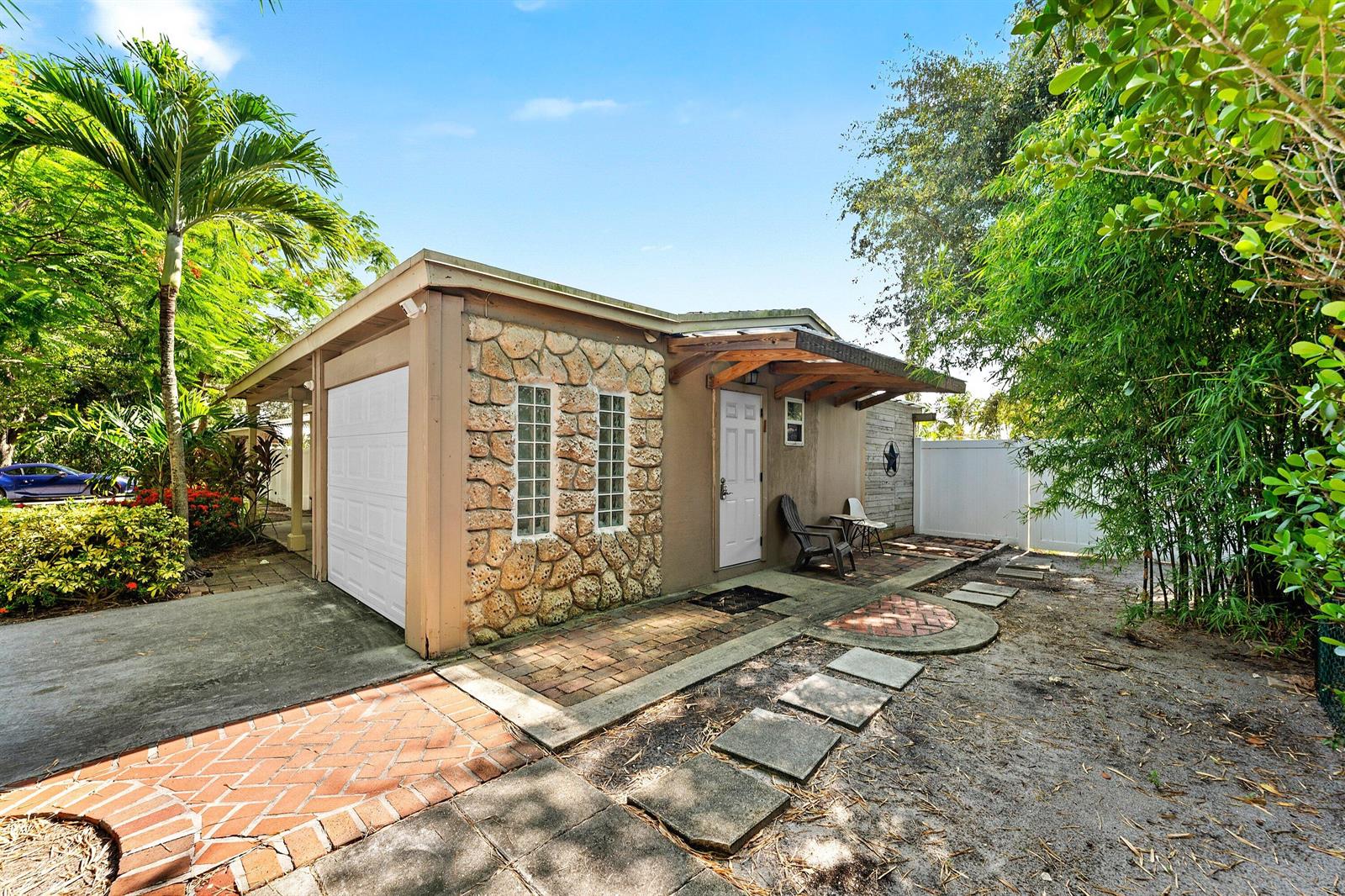 A detached garage with stone veneer, glass block windows, and a brick patio area — 1638 NE 3rd Avenue, Delray Beach FL 33444, DELRAY BEACH, FL