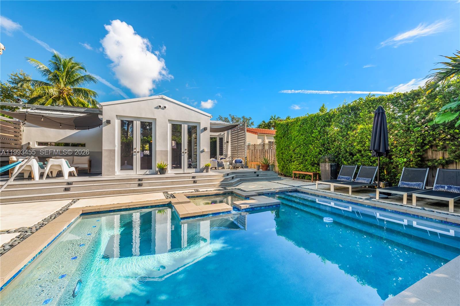 A backyard features a swimming pool, a hot tub, and a patio with lounge chairs — 738 NE 72nd Ter, Miami FL 33138, MIAMI, FL