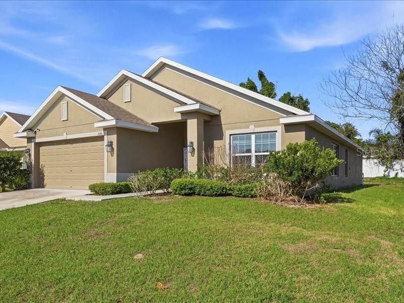 A tan, single-story suburban house with a two-car garage and a front lawn — 1646 TRESSEL COURT, WINTER HAVEN, FL
