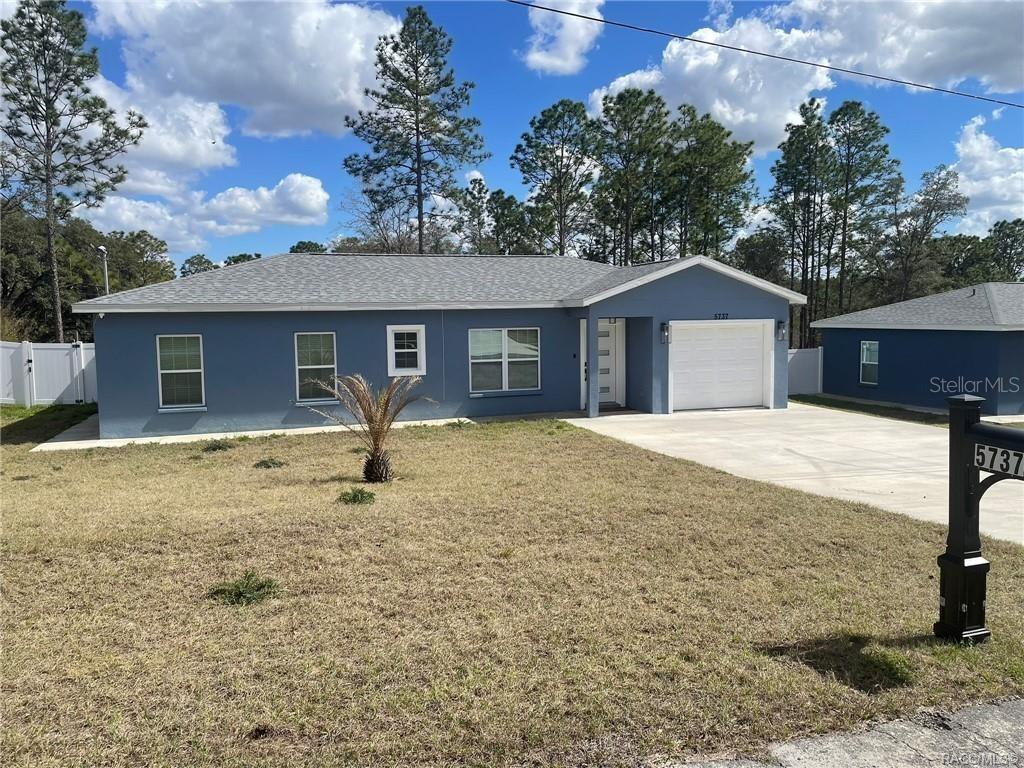 A blue single-story house with a white garage door and a concrete driveway — 5737 N CLAREMONT DRIVE, CITRUS SPRINGS, FL