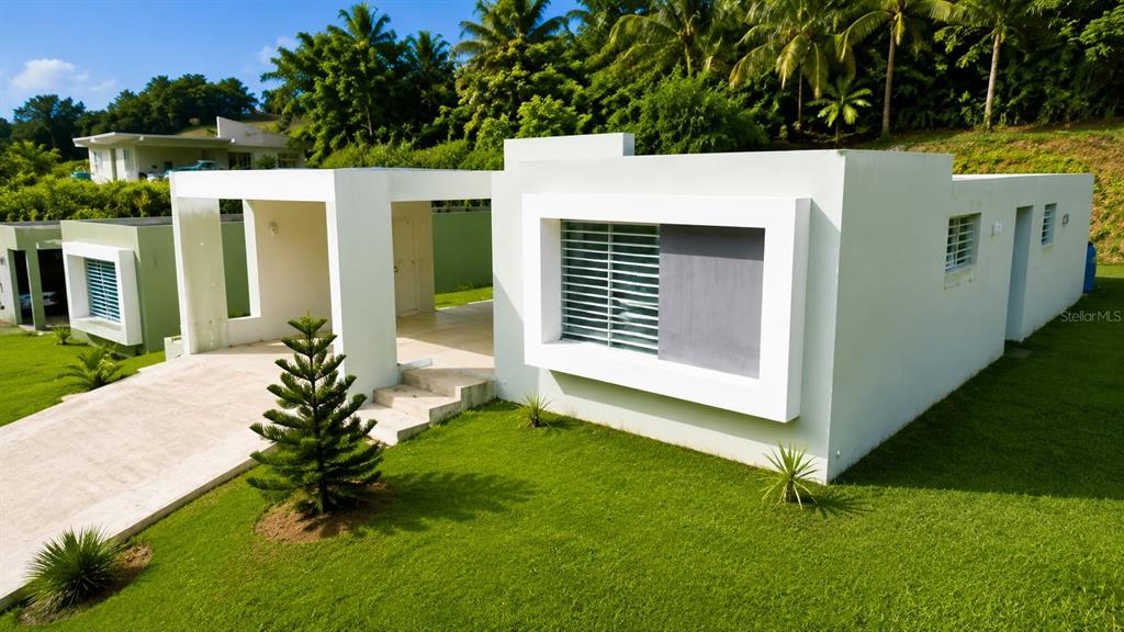 A modern white house with a flat roof sits on a grassy lawn — 115 km 13.2 BO PUEBLO, RINCON, PR