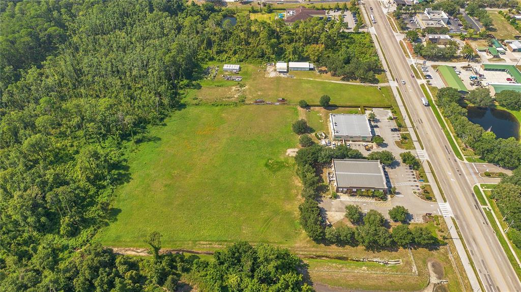 An aerial view shows two commercial buildings situated on a large lot next to a substation — ROCK SPRINGS ROAD, APOPKA, FL