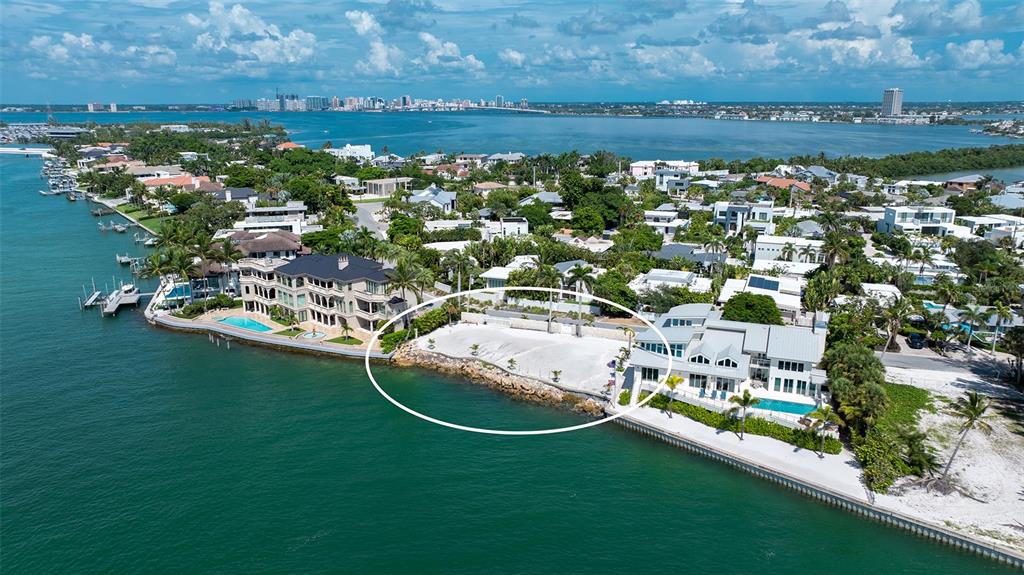 An aerial view shows a waterfront residential lot with a sandy beach between two houses — 1215 WESTWAY DRIVE, SARASOTA, FL