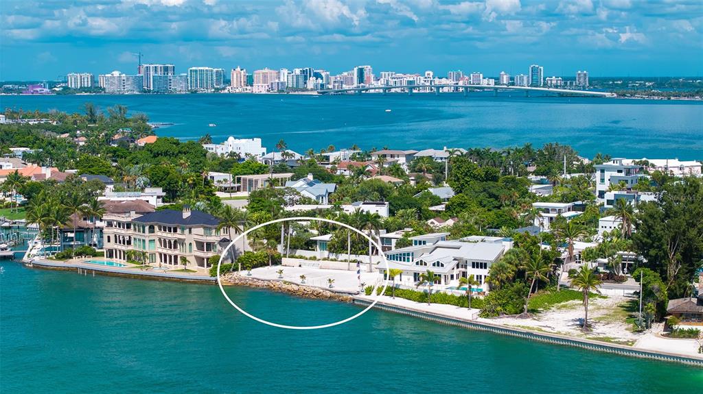 An aerial view of a waterfront property featuring a sandy beach area and a seawall — 1215 WESTWAY DRIVE, SARASOTA, FL