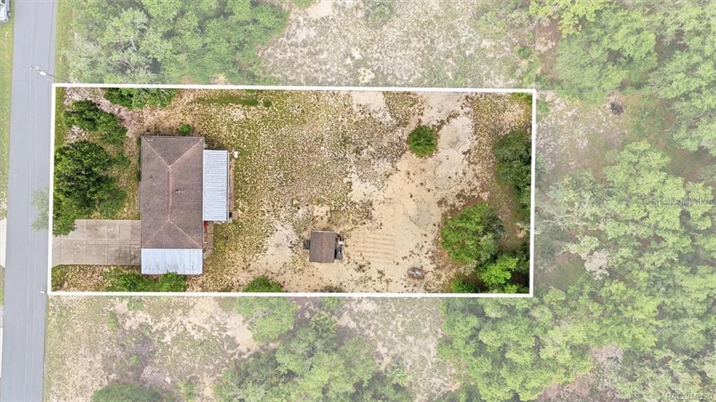 An aerial view shows a house and a small shed on a large, sandy lot — 9734 E GRANADA COURT, INVERNESS, FL