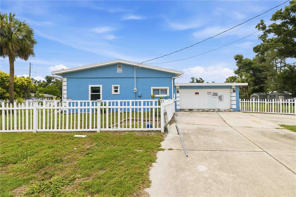 A blue single-story house features a white picket fence and a concrete driveway — 3706 OLD BRADENTON ROAD, SARASOTA, FL