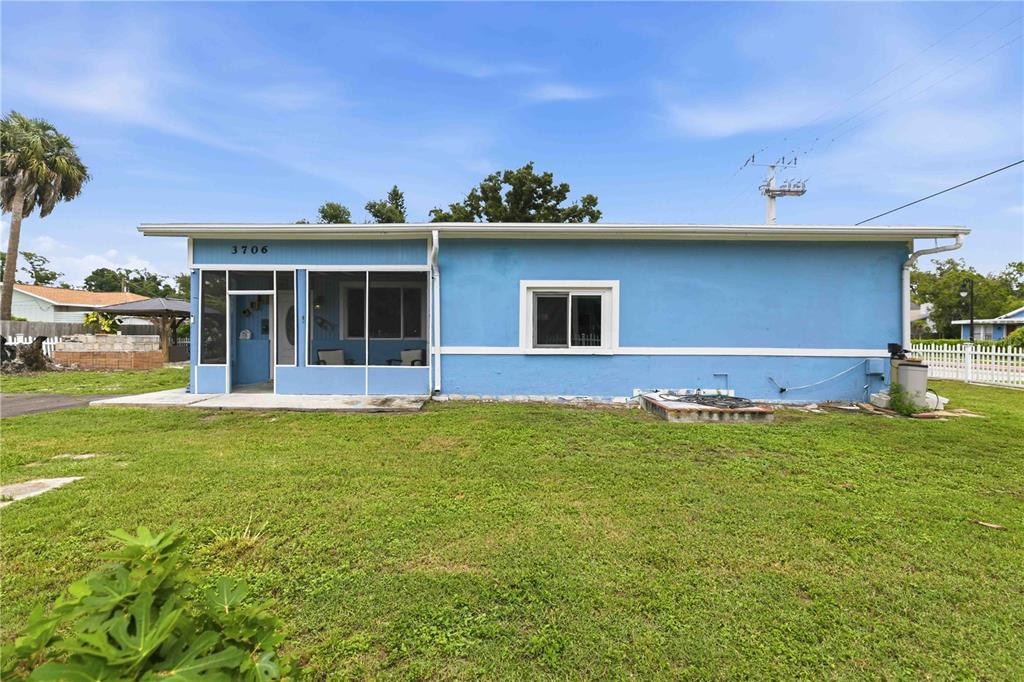 A blue single-story house features a screened-in front porch and a large grassy yard — 3706 OLD BRADENTON ROAD, SARASOTA, FL