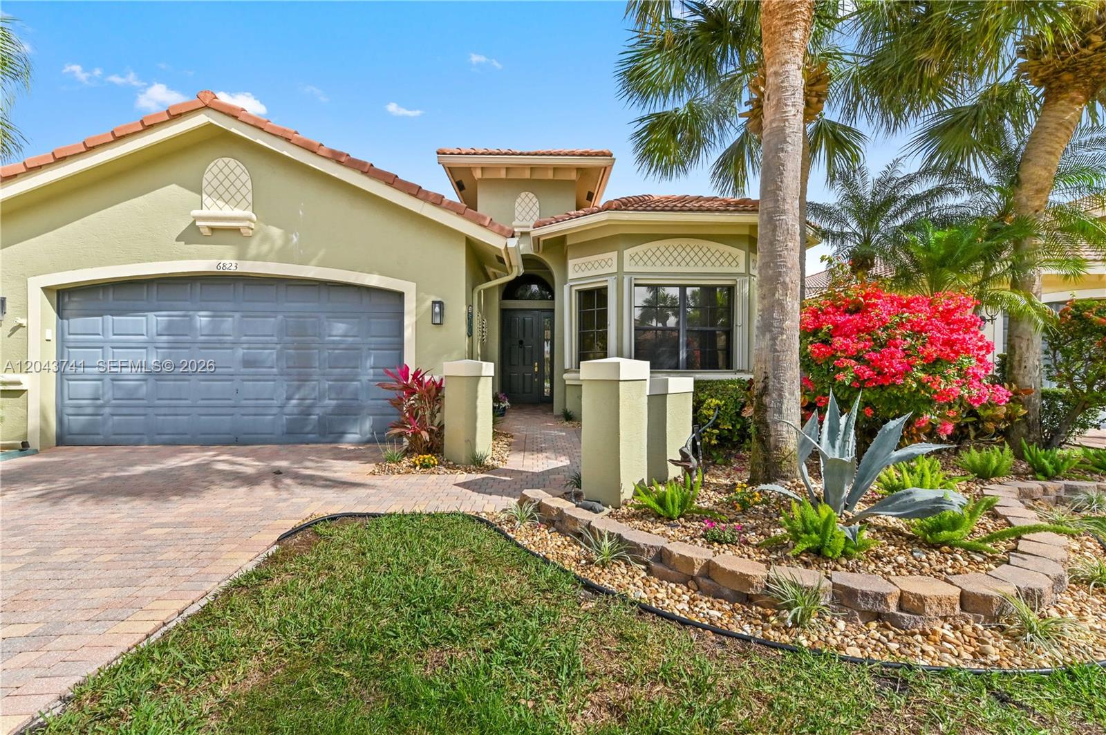 A single-story house with a garage, tiled roof, and landscaped front yard — 6823 Fabiano Cir, Boynton Beach FL 33437, BOYNTON BEACH, FL