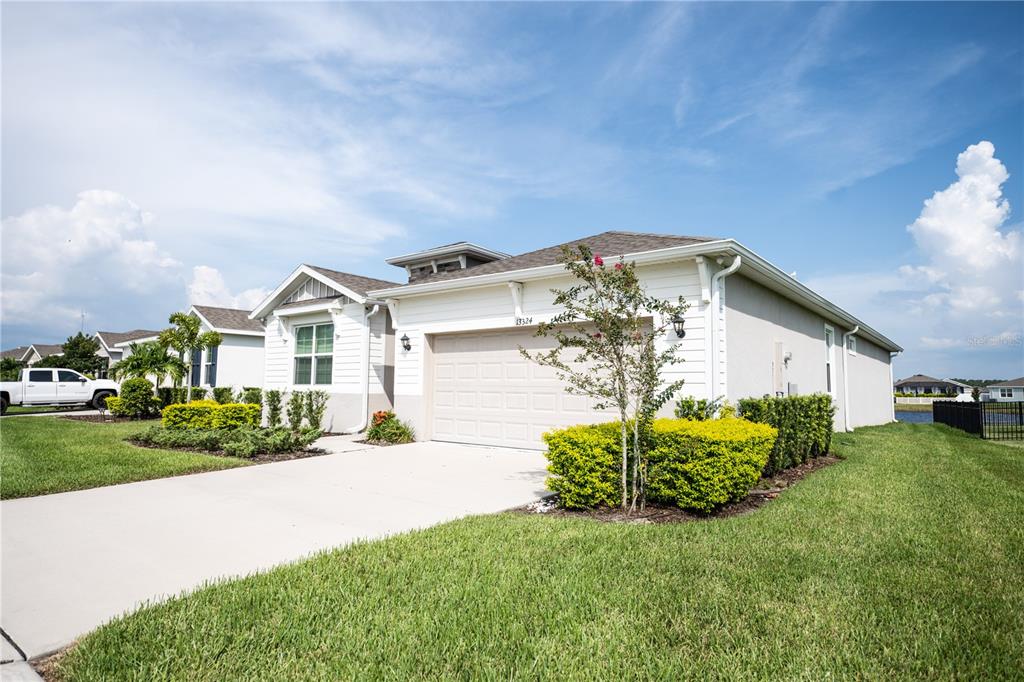 A single-story house with a beige garage, white siding, and a concrete driveway — 13324 WATERLEAF GARDEN CIRCLE, RIVERVIEW, FL