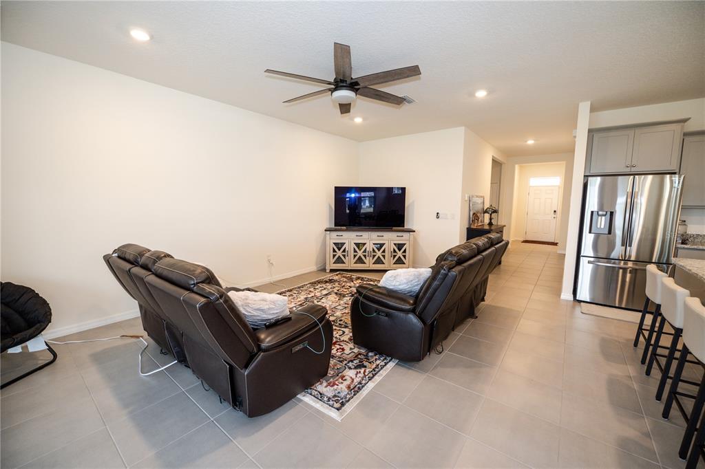 A living room with two leather recliners, a television console, and tile flooring — 13324 WATERLEAF GARDEN CIRCLE, RIVERVIEW, FL