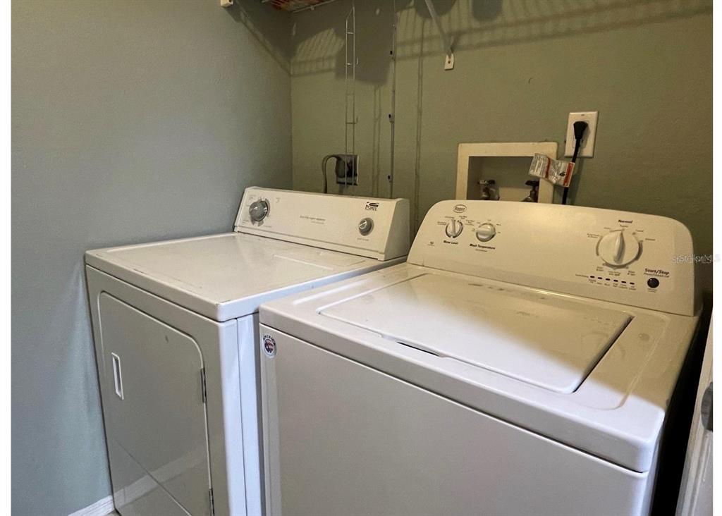 A laundry room contains a white top-loading washing machine and a matching dryer — 3705 SW 27TH STREET UNIT 1113, GAINESVILLE, FL