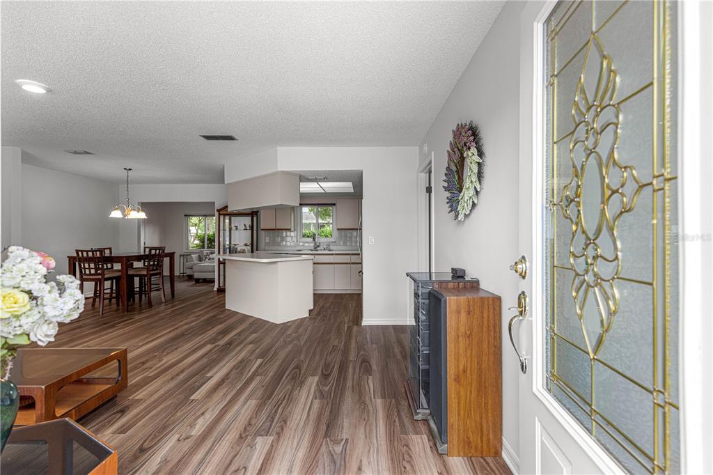 An entryway leads into an open-concept dining area and kitchen with wood-look flooring — 10956 SW 62ND TERRACE, OCALA, FL