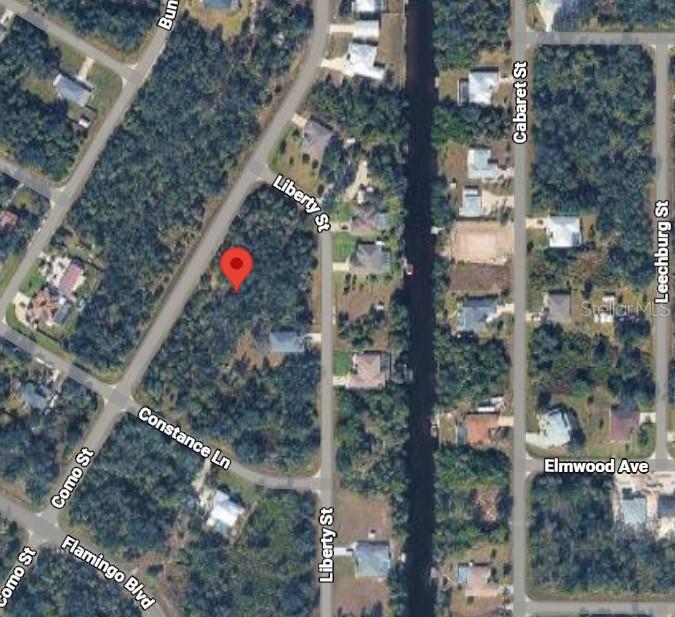 This is an aerial map showing a vacant, wooded residential lot marked with a red pin — 3296 COMO STREET, PORT CHARLOTTE, FL