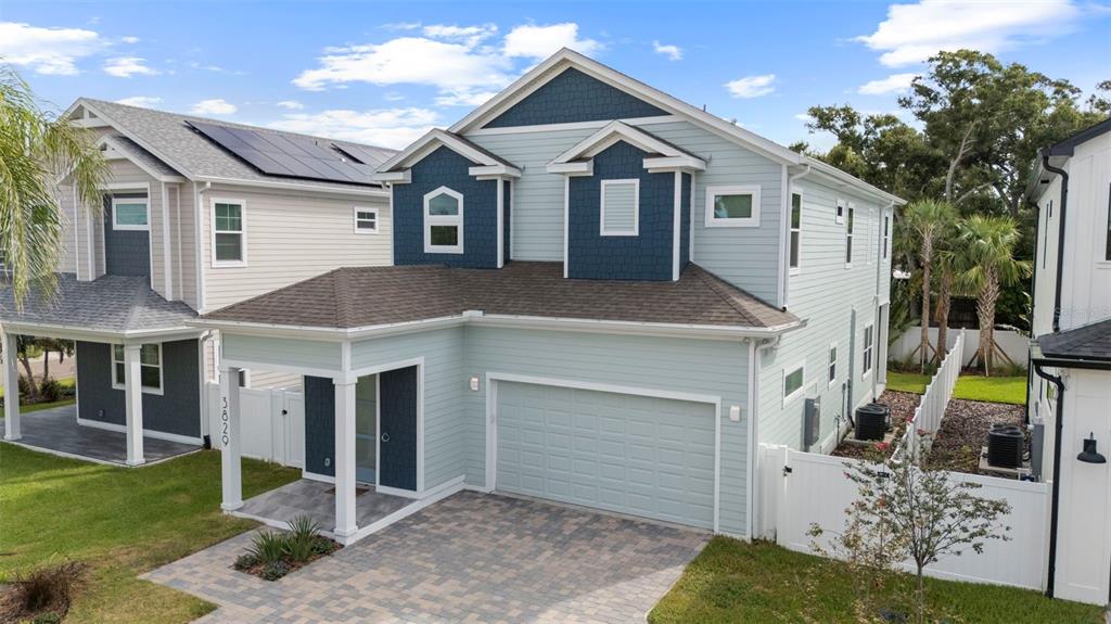 A two-story house with light blue siding, dark blue accents, and a paved driveway — 3829 71ST STREET N, ST PETERSBURG, FL