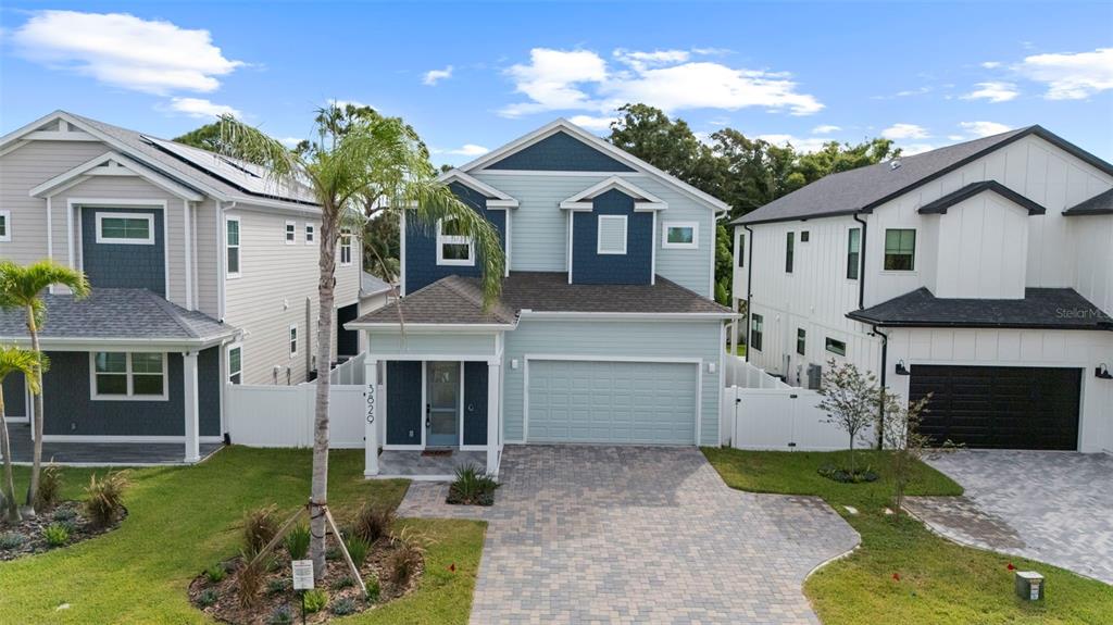 An exterior view of a two-story house with light blue siding and a paved driveway — 3829 71ST STREET N, ST PETERSBURG, FL