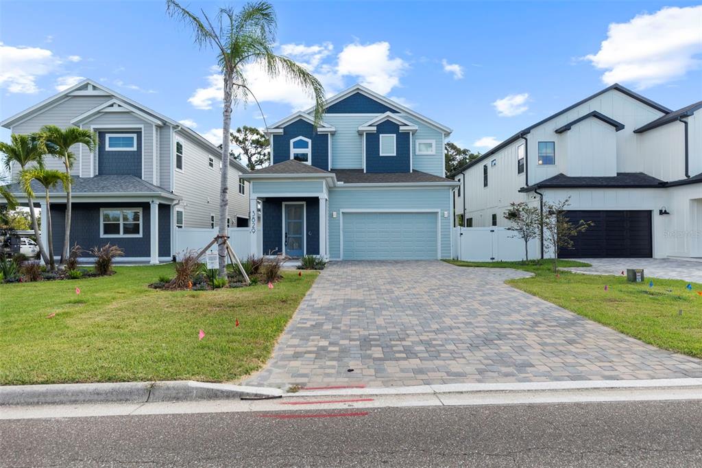 A two-story house with a light blue exterior, dark blue accents, and a paved driveway — 3829 71ST STREET N, ST PETERSBURG, FL