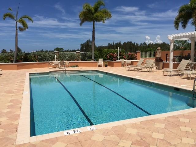 A rectangular swimming pool with a six-foot depth marker sits on a paved patio deck — 3191 MATECUMBE KEY ROAD UNIT 303, PUNTA GORDA, FL