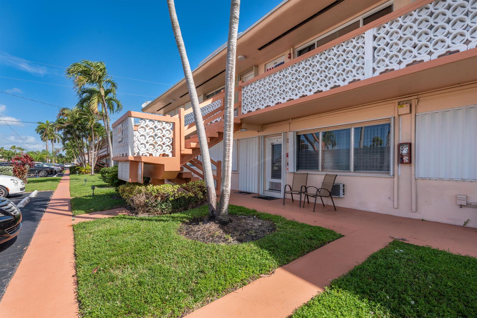 An exterior view of a two-story apartment building with a staircase and palm trees — 925 SW 11th Avenue # 3j, FL 33009, FL
