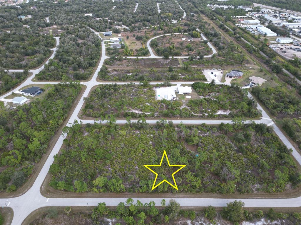 An aerial view shows a vacant, wooded residential lot marked with a yellow star — 13250 ROUDING CIRCLE, PORT CHARLOTTE, FL
