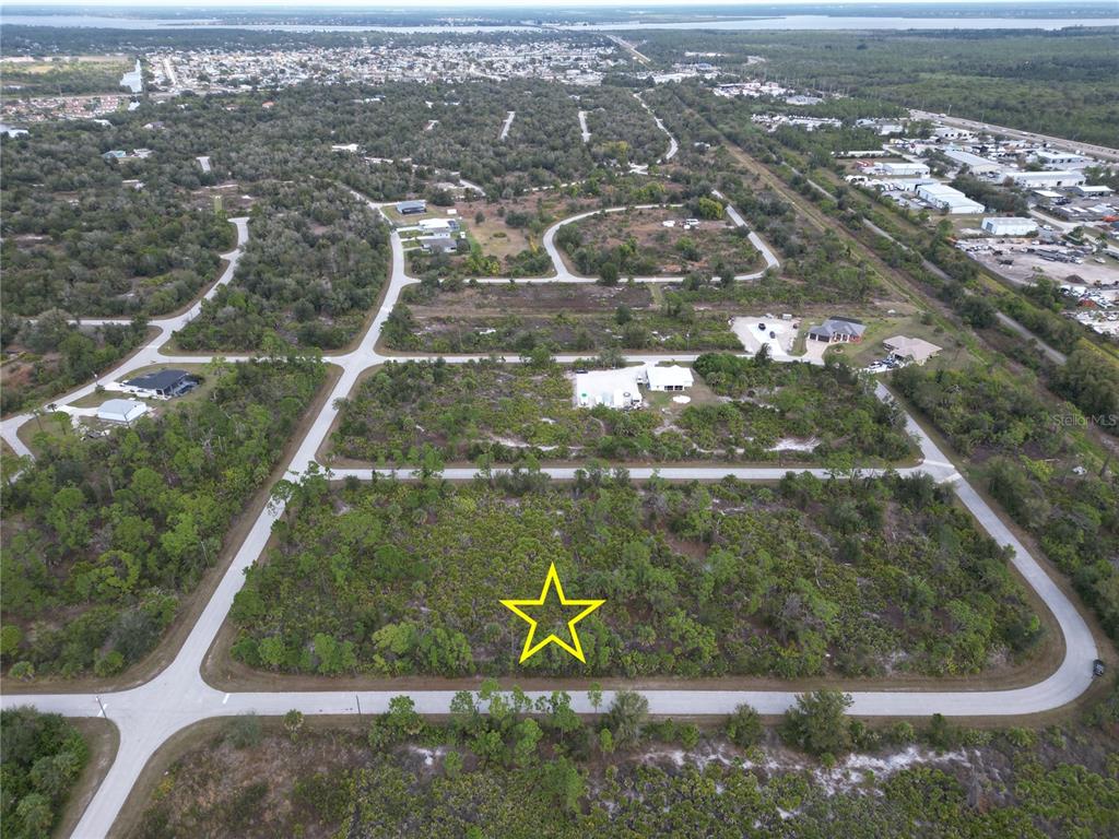 An aerial view shows a vacant, wooded residential lot marked with a yellow star — 13250 ROUDING CIRCLE, PORT CHARLOTTE, FL