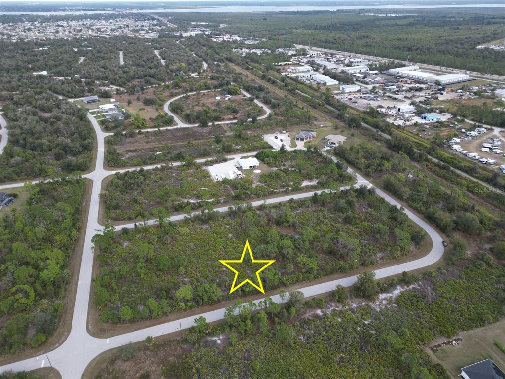 An aerial view shows a vacant, wooded residential lot marked with a yellow star — 13250 ROUDING CIRCLE, PORT CHARLOTTE, FL