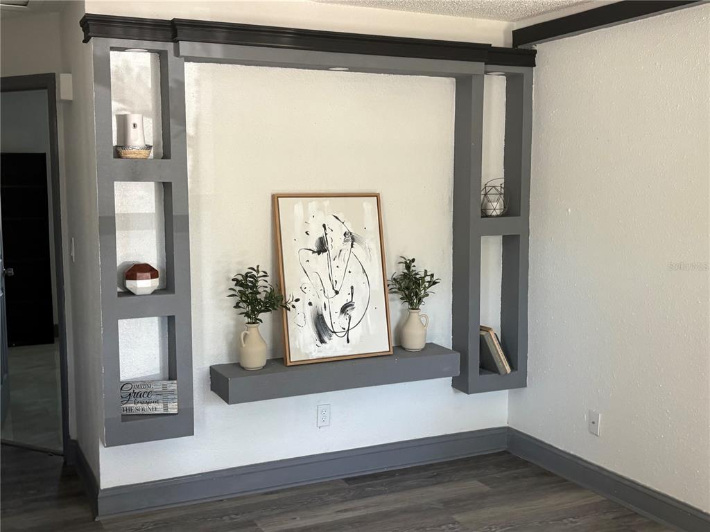 A living room features a gray built-in wall unit with shelving and a central display shelf — 7019 N WILLOW AVENUE, TAMPA, FL