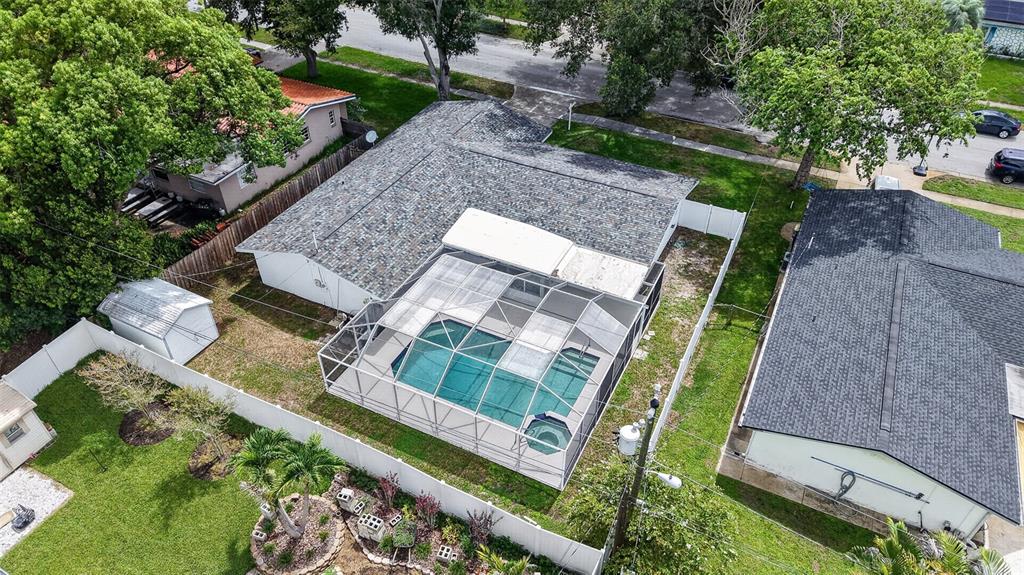 An aerial view shows a house with a screened-in pool and a fenced backyard — 700 RUSKIN ROAD, CLEARWATER, FL